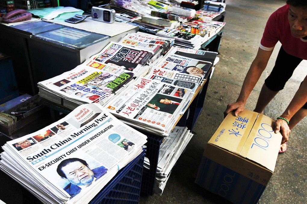 A vendor works beside Hong Kong newspapers showing photos of Zhou Yongkang. China's Communist Party said it had launched a an investigation into the former domestic security chief as part of its crackdown on corruption. Photo: Reuters