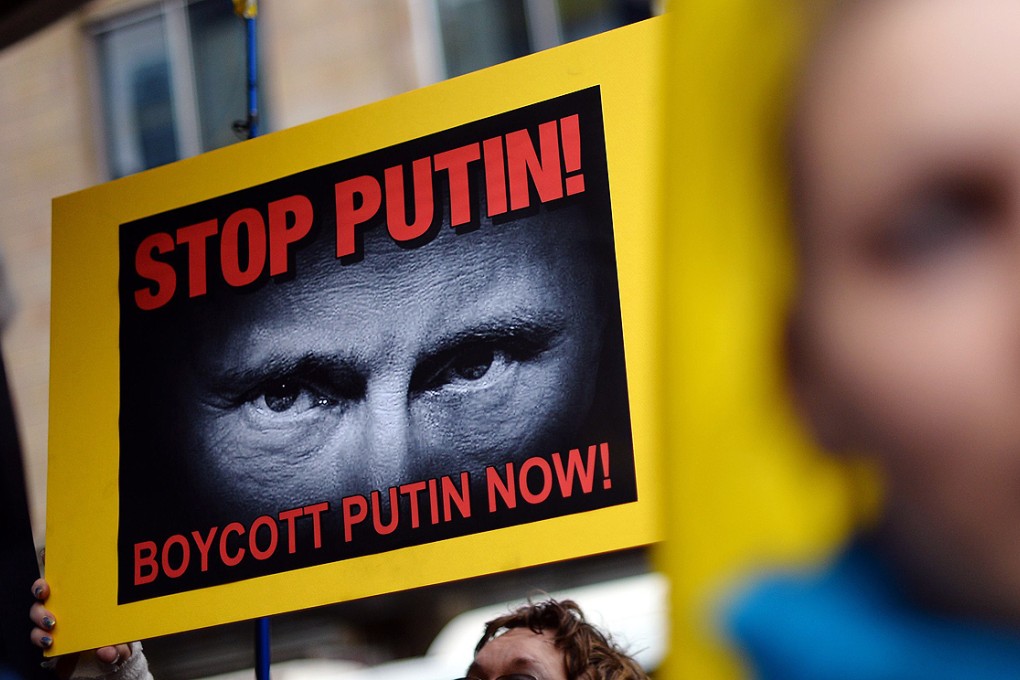 Members of the Australian Ukrainian community hold placards carrying pictures of Russian President Vladimir Putin during a protest rally in Sydney. Photo: AFP
