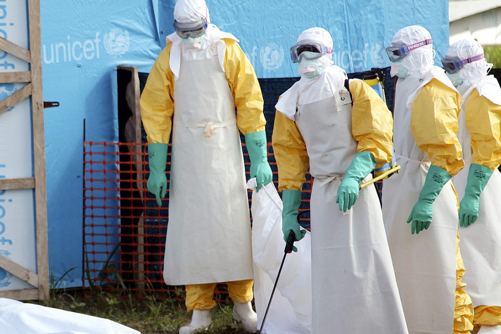 Liberian health workers about to load the body of a woman who died from the Ebola virus into a pickup at the isolation unit in Foya, Lofa County, Liberia. Photo: EPA