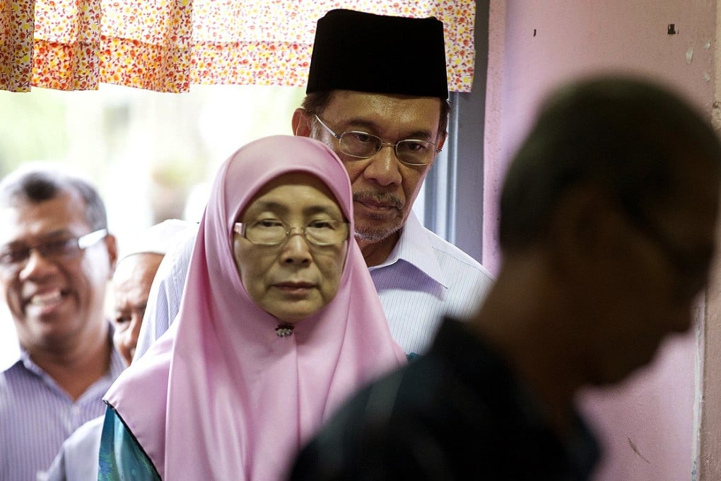 Anwar Ibrahim stands behind his wife Wan Azizah. Photo: AP