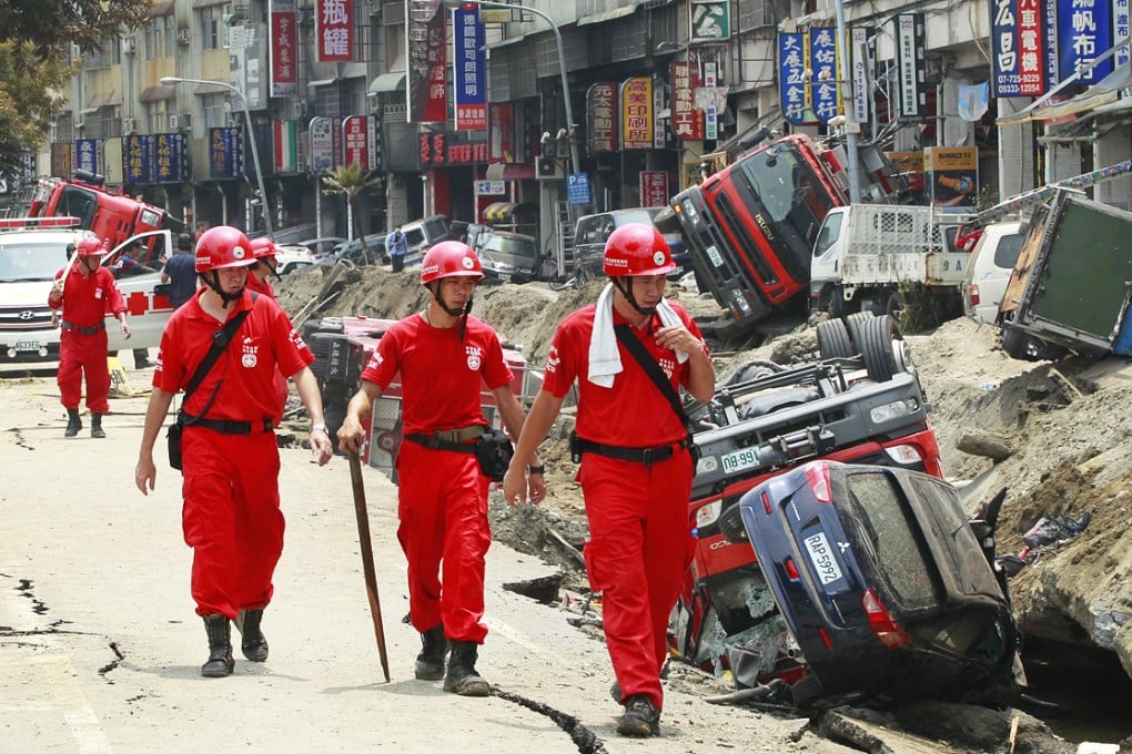 An emergency rescue team searches for missing people as damaged vehicles sit on side of the road after massive gas explosions in Kaohsiung in Taiwan. Photo: AP