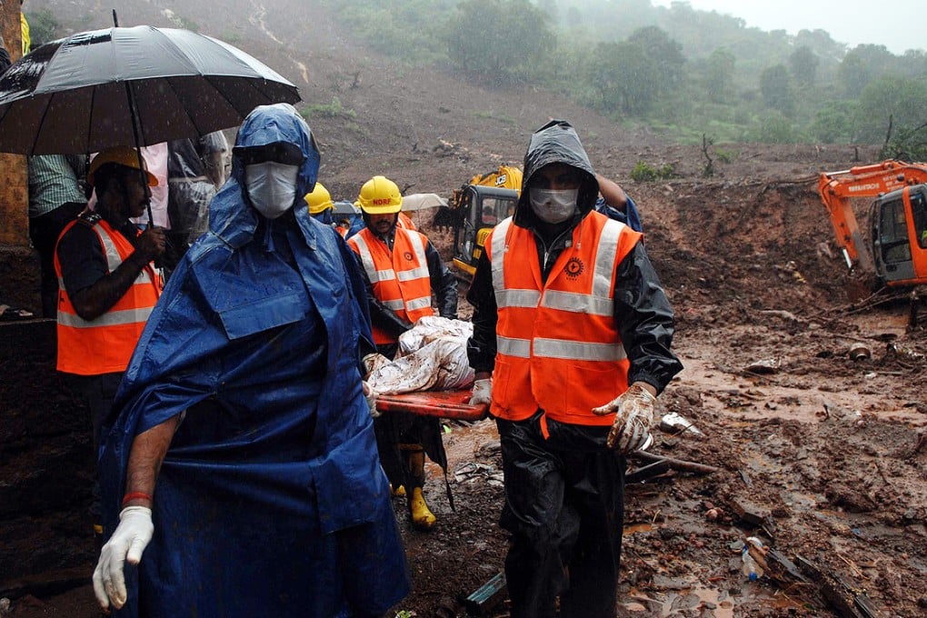 Workers from the National Disaster Management Force carry a body during a rescue operation after a landslide in Malin village, India on Thursday. Photo: Xinhua