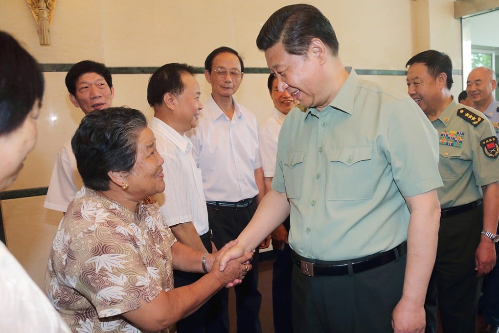 Xi Jinping (right front) talks with a model worker of supporting both the army and the government in Fujian Province. Photo: Xinhua