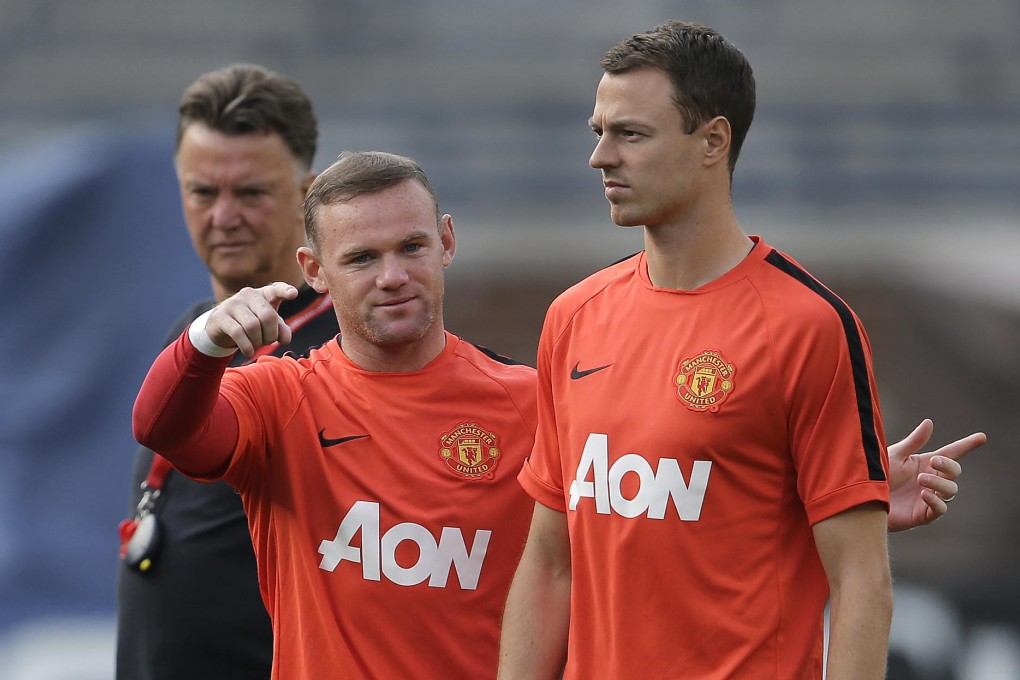 Manchester United striker Wayne Rooney and defender Jonny Evans during a training session as their manager Louis van Gaal lurks in the background. Photo: AP
