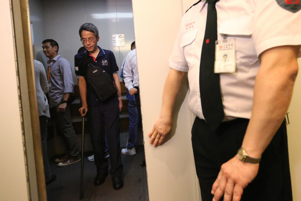 Kevin Lau relies on a crutch as he returns to the offices of Ming Pao for the first time since the attack in February. Photo: Felix Wong