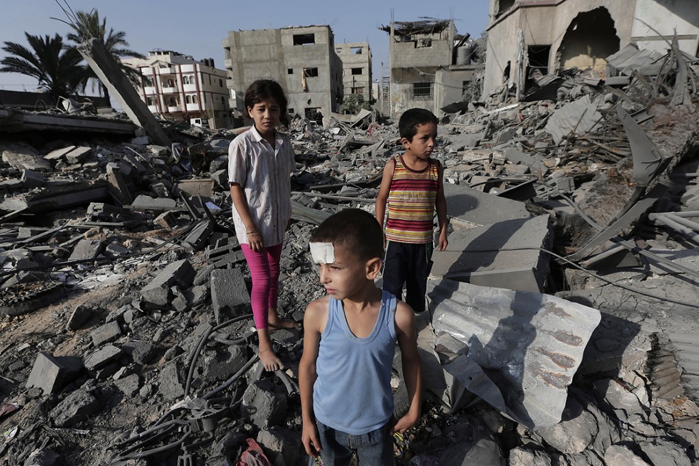 Palestinian five-year-old Seraj Ismail Abdel Al, lightly wounded in an Israeli strike overnight, views damage to buildings in the northern Gaza Strip on Saturday. Photo: AP