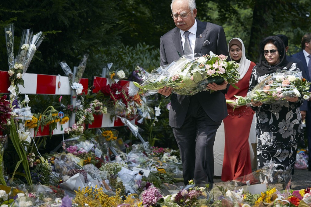 Malaysian Prime Minister Najib Razak lays flowers among other flower tributes outside a military barracks where forensic experts identify bodies recovered from the wreckage of Flight 17. Photo: AP