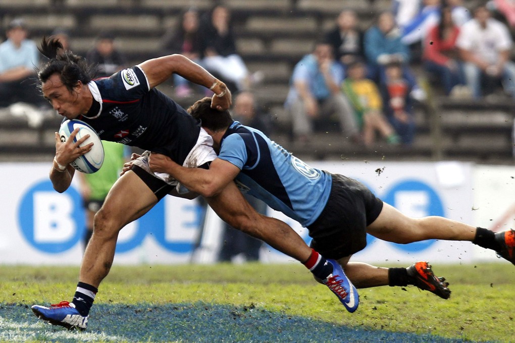 Hong Kong winger Salom Yiu Kam-shing is tackled by Uruguay's Jeronimo Etcheverry during the World Cup repechage clash in Motevideo. Photo: EPA