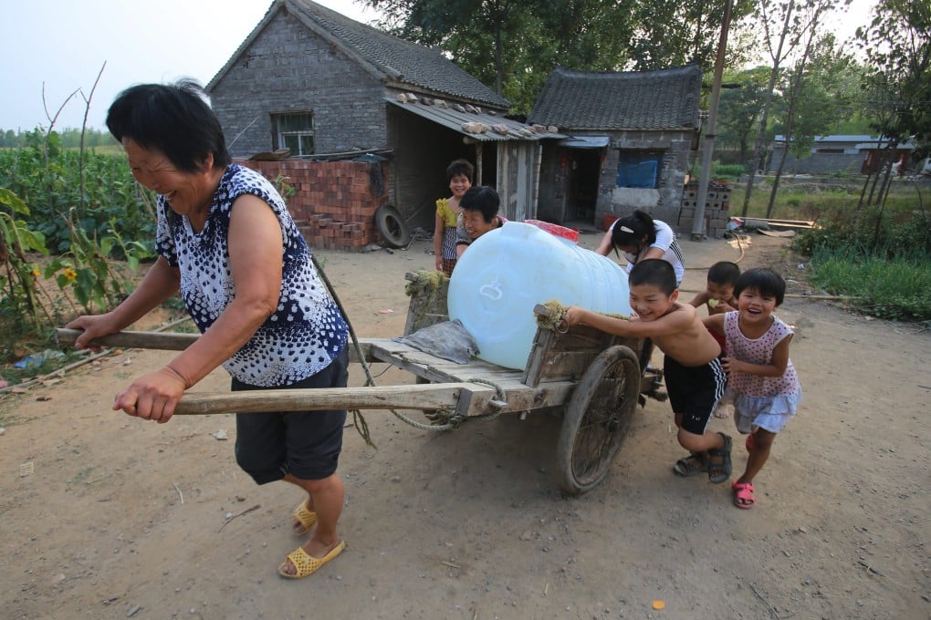 Villagers transport a water storage tank to their home for drinking water in Lushan county in Henan province. Photo: EPA