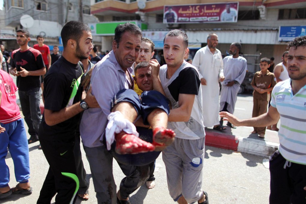 A wounded man is carried from the UN shelter in Rafah. Photo: EPA