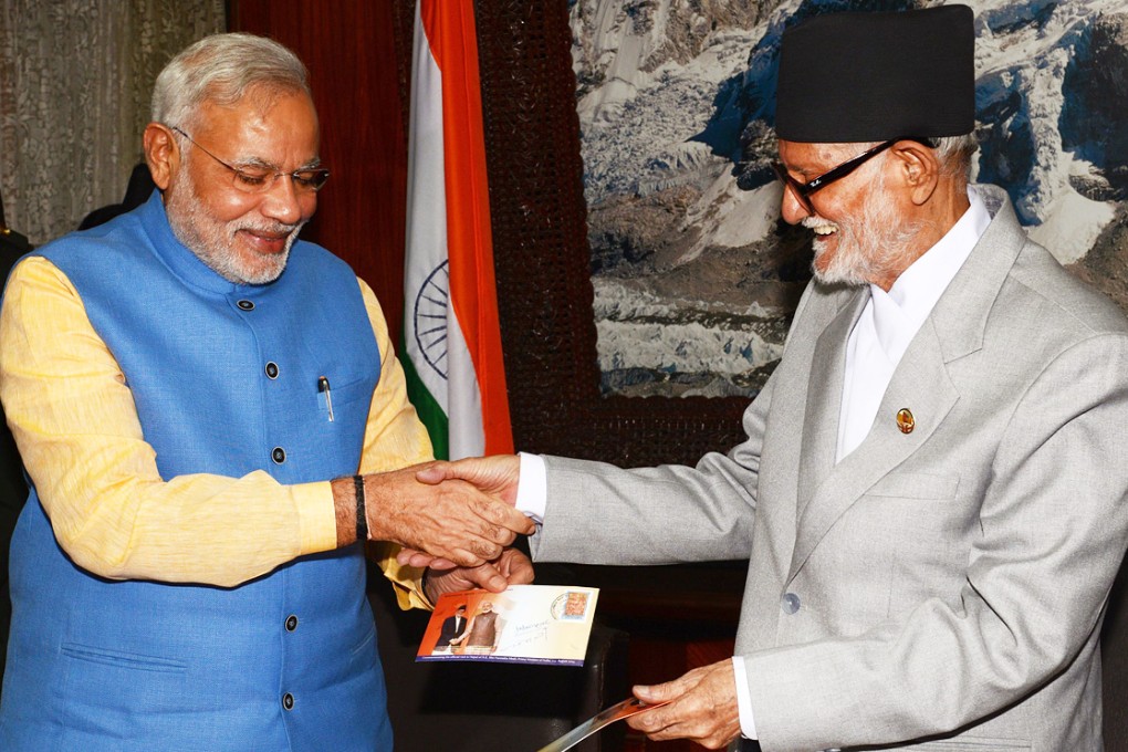 India's Prime Minister Narendra Modi (left) shakes hands with Nepali Prime Minister Sushil Koirala after issuing postal stamps at Prime Minister's office in Kathmandu, Nepal. Photo: Xinhua