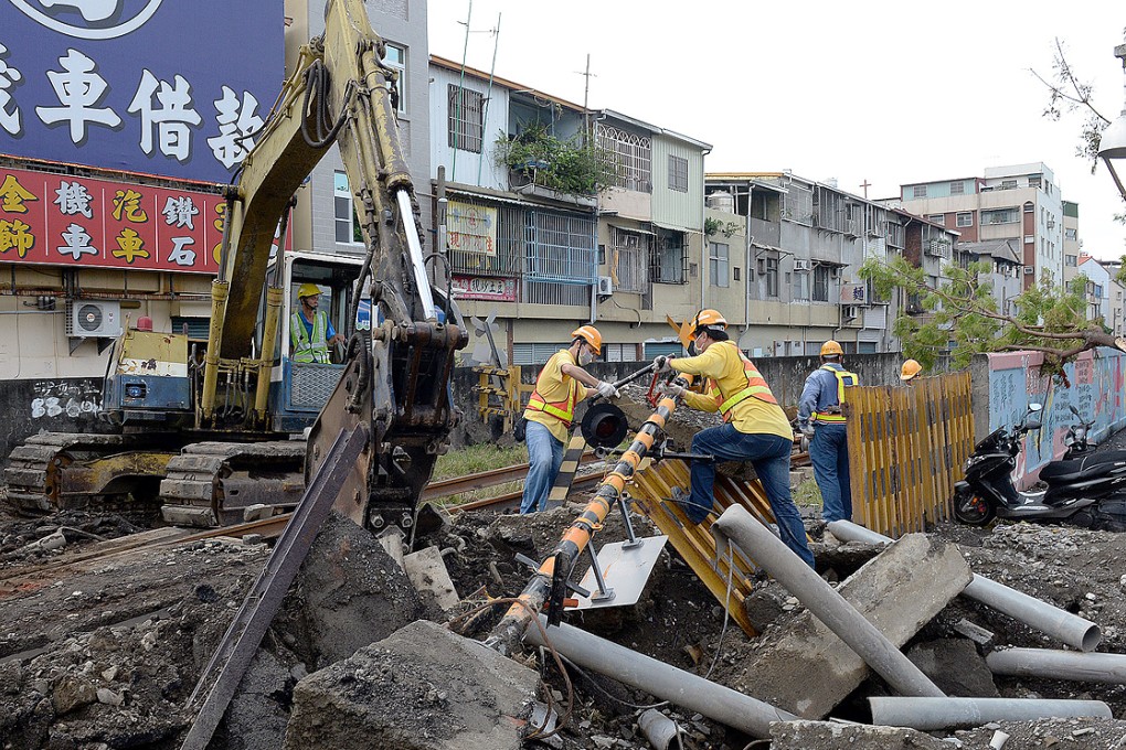 Workers clear debris from an intersection in Kaohsiung. Two firefighters are still missing from the explosions that killed at least 28 people. Photo: XInhua