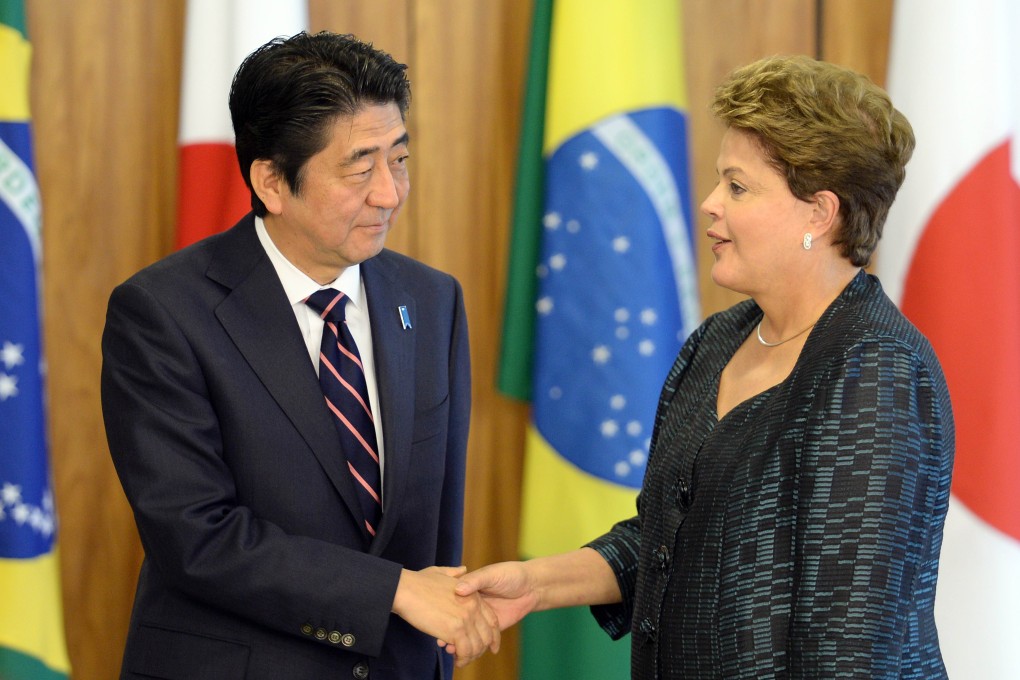 Japan's Prime Minister Shinzo Abe (L) and Brazilian President Dilma Roussefff shake hands after a ceremony of signature of agreements at Planalto Palace in Brasilia. Photo: AFP