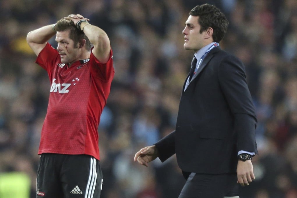 Injured Waratahs’ captain Dave Denis walks past a disappointed Richie McCaw after the Canterbury Crusaders lost the Super Rugby final 33-32 on Saturday. Photo: AP