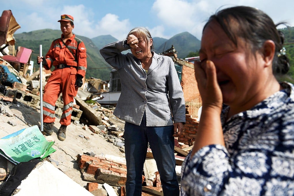 Relatives of 71-year-old He Guixiu react as her body is found at a collapsed house at Longtoushan. Photo: AFP
