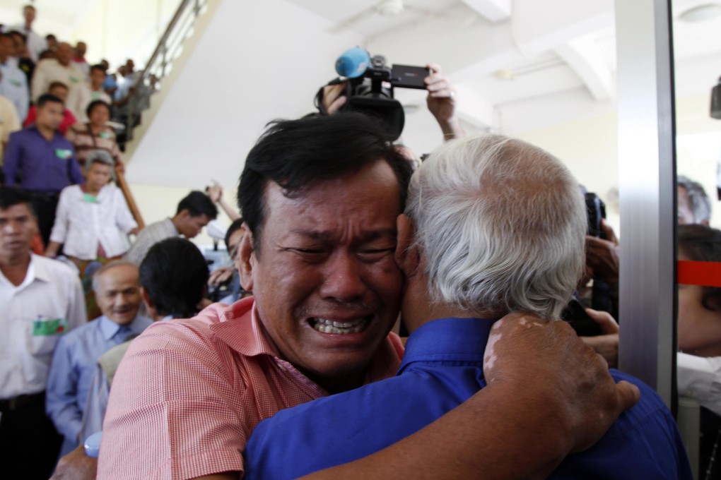 Survivors of the Khmer Rouge regime embrace as the verdict is announced. About 900 Cambodians attended the court. Photo: AP