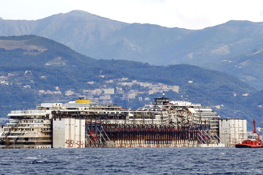 Tug boats tow the Costa Concordia ship as they arrive outside Genoa's port, in northern Italy, where the ship will be broken up for scrap. Photo: Reuters