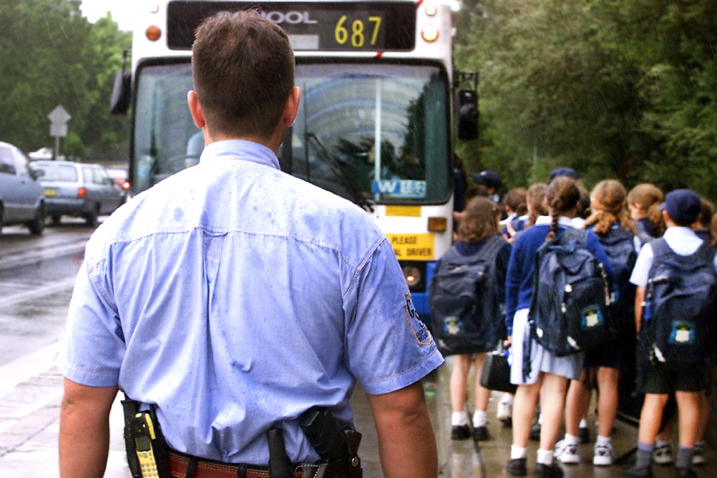 An armed guard watches over students leaving Moriah War Memorial College, a Jewish school in Bondi, in this file photo. Jewish schoolchildren became the target of a teenage gang chanting 'Free Palestine' on Wednesday. Photo: AFP