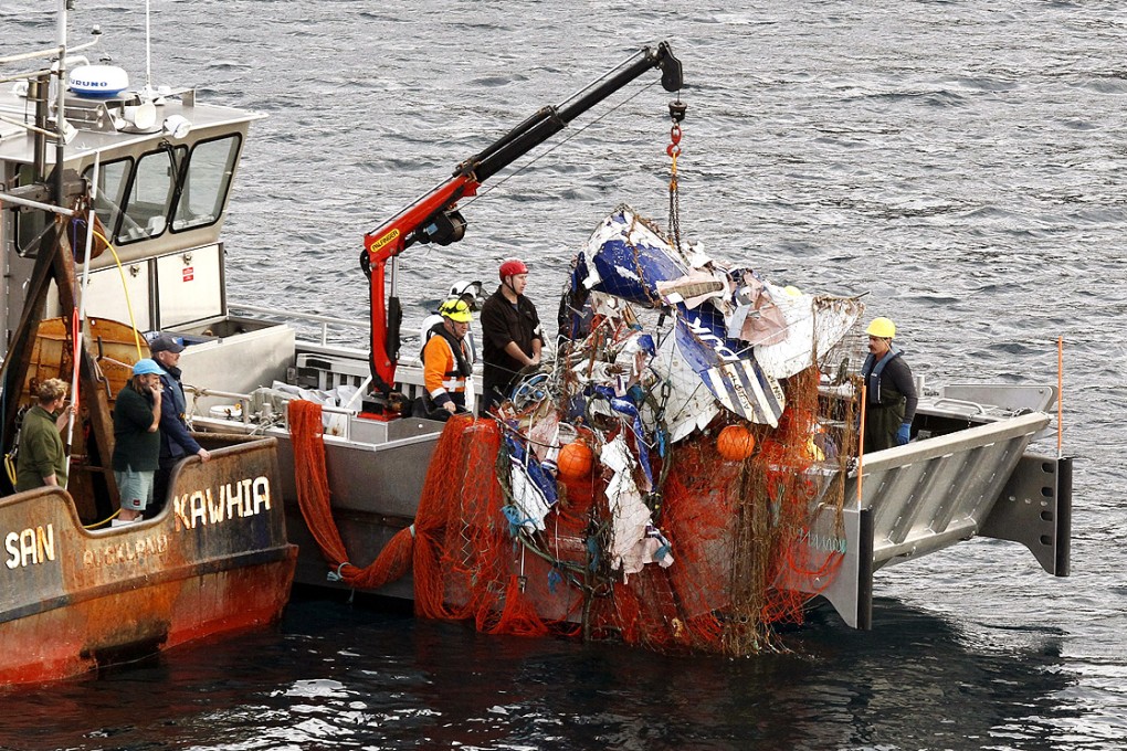 The wreckage of a small plane is hauled onto a fishing trawler after becoming caught in its nets near Auckland, New Zealand, on Thursday. Photo: AP