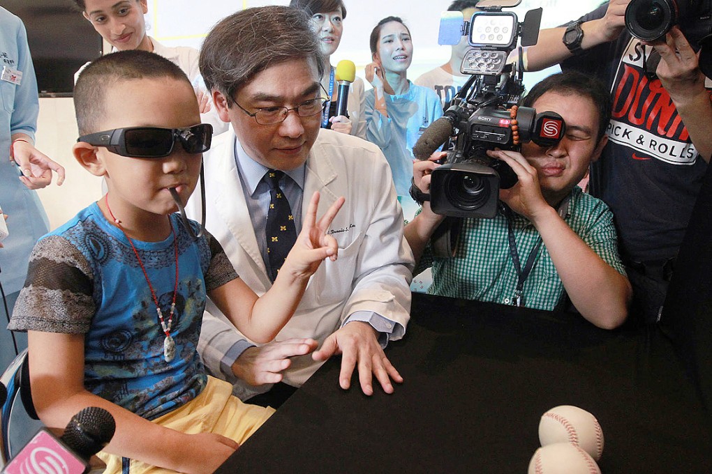 Bin-Bin shows off hi-tech glasses that translate images into pulses he can "read" with his tongue. Photo: Edward Wong