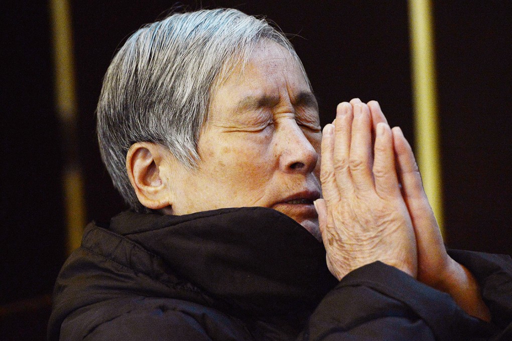 A woman prays at a cathedral in Beijing. Experts estimate that there were as many as 12 million Catholics on the mainland as of last year, with about half of the congregations under a state-sanctioned association. The rest belong to non-sanctioned or so-called 'underground' churches. Photo: AFP