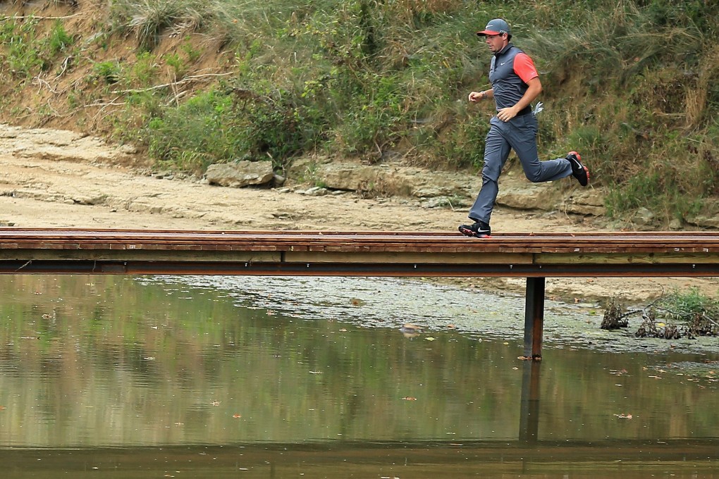 Rory McIlroy runs over the bridge to the ninth fairway after a bathroom break during the first round of the 96th PGA Championship at Valhalla Golf Club. McIlroy is one shot off the lead. Photo: AFP
