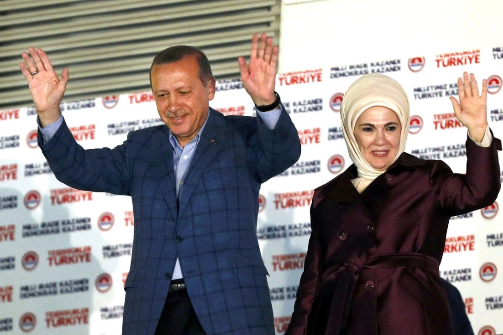 Recep Tayyip Erdogan and his wife Ermine wave to thousands of supporters at his party headquarters in Ankara. Photo: Reuters