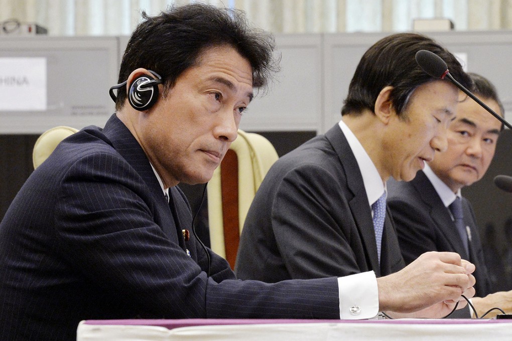 Minister of Foreign Affairs of Japan Fumio Kishida (left) addresses during the Foreign Ministerial meeting as his Chinese counterpart Wang Yi (right) looks on. Photo: Kyodo