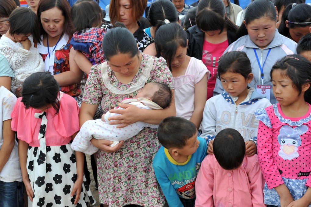 People bow their heads in Wenping town, Ludian county, during a
three-minute silence held throughout Yunnan province at
10am yesterday – seven days after a magnitude-6.5 earthquake
struck the impoverished region. Photo: Xinhua