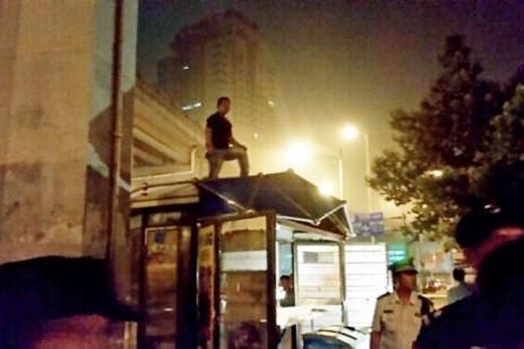 A news stand owner in Beijing's Chaoyang district tries to keep authorities from demolishing his livelihood. Photo: SCMP Pictures