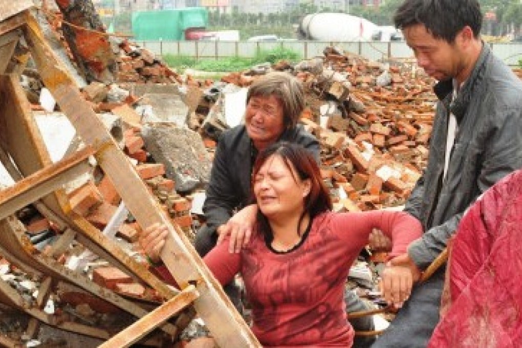 People weep over what remains of their house, in unverified photos from the scene. Photo: Weibo