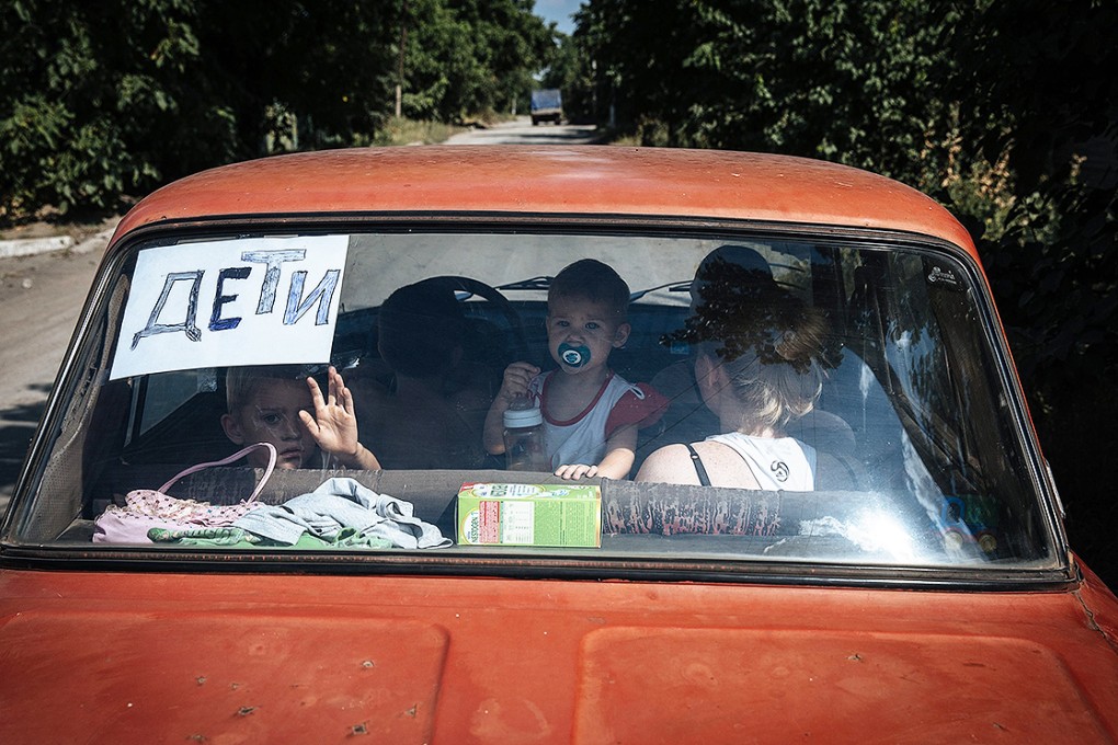 A sign reading 'Children' is seen on a car's back windscreen as civilians drive through the Donetsk region. Photo: EPA