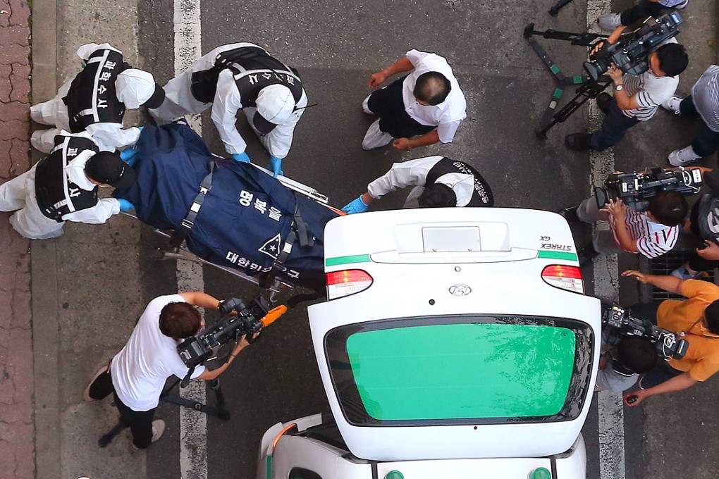 South Korean military investigators carry a body to an ambulance at an apartment in Seoul. Photo: AFP