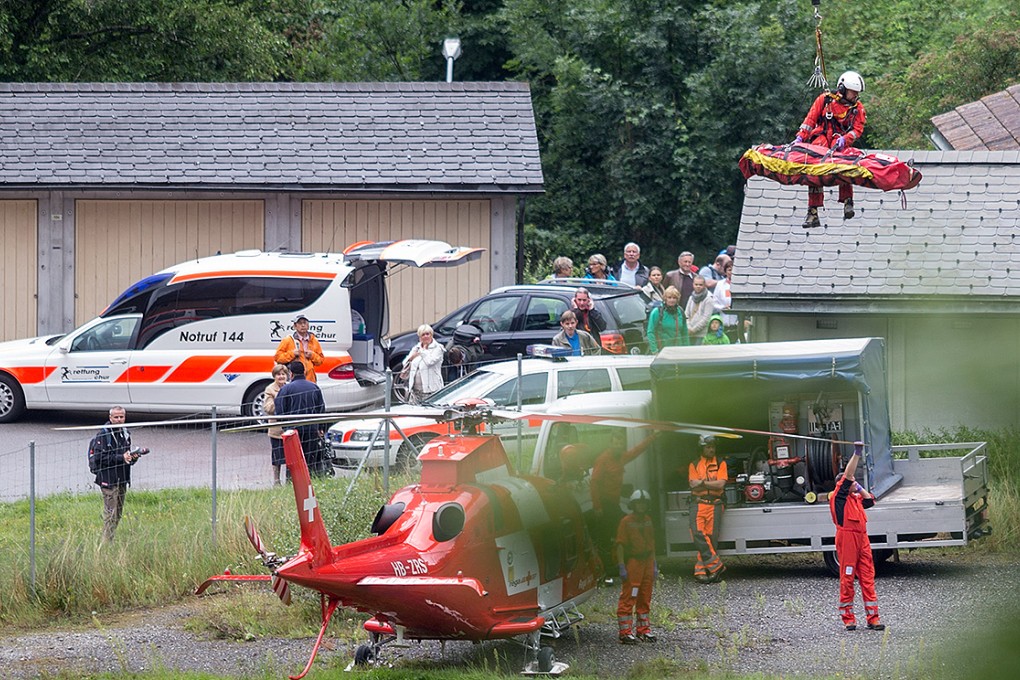 Rescue forces recover a victim of a train crash near Tiefencastel. Photo: AP