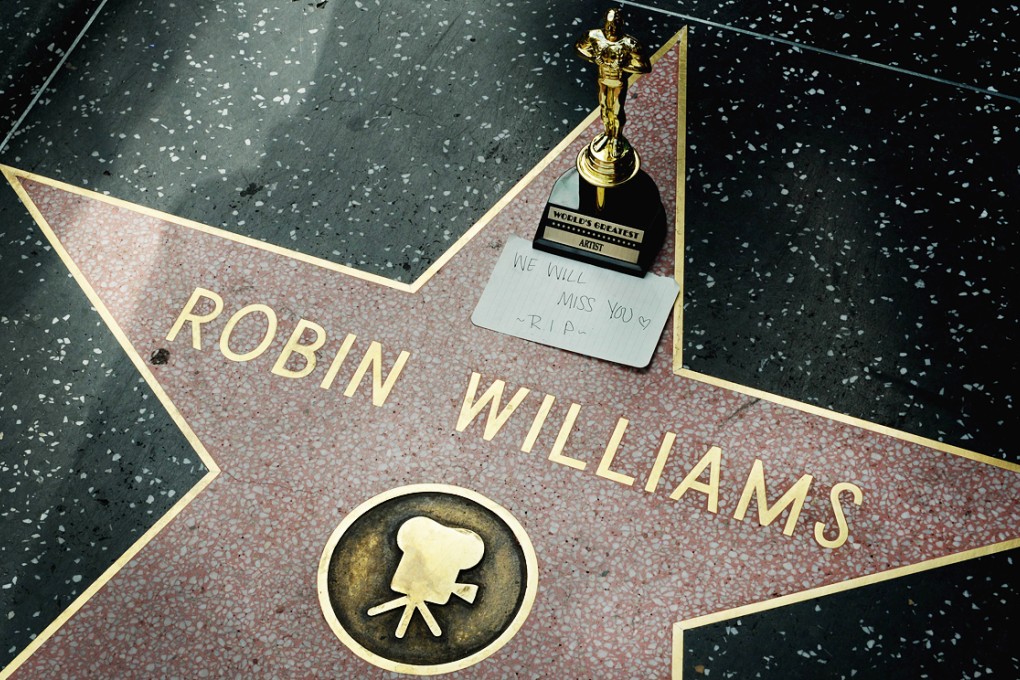 A miniature Oscars statue and an "I will miss you" note is seen at Robin Williams' star on the Hollywood Walk of Fame. Photo: AFP