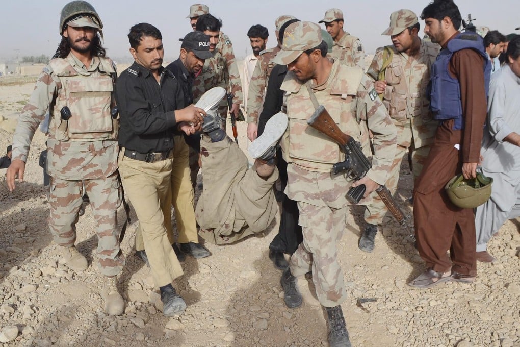 Pakistani security officers inspect the body of a suspected militant at a base in Quetta. Photo: EPA