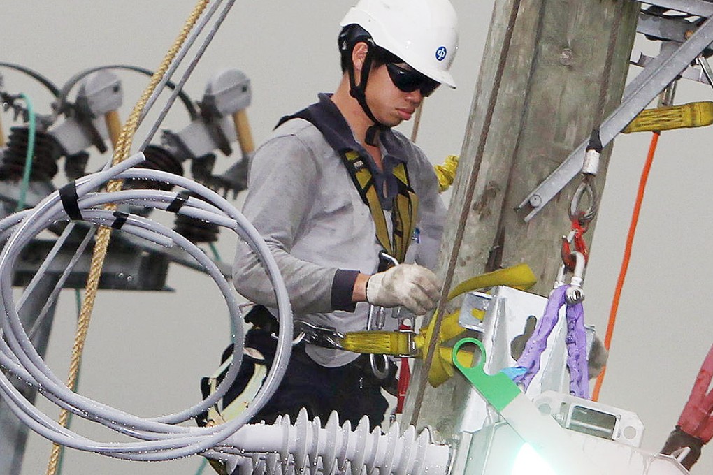 A CLP employee works on a power line. Photo: Felix Wong