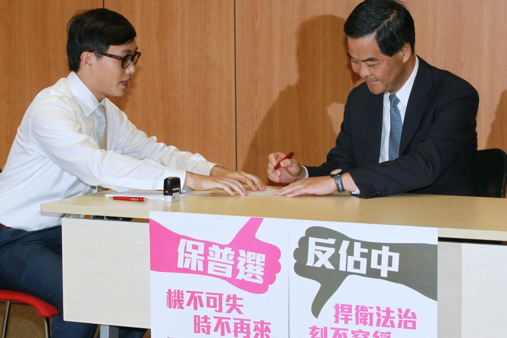 Chief Executive Leung Chun-ying (right) pens his name in support of the anti-Occupy Central campaign. Photo: Edward Wong