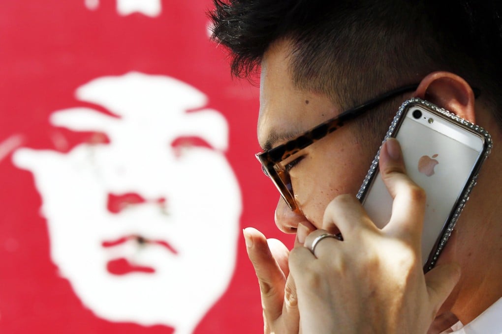 A man talks on an iPhone in Beijing. The iCloud service enables users to automatically store files from their Apple devices into a storage "locker" online. Photo: Reuters