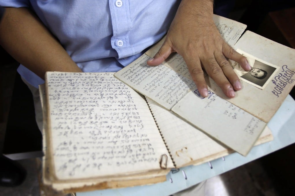 The diary in the hands of Youk Chhang, who is in charge of the archives at the Documentation Centre of Cambodia in Phnom Penh. Photo: AP