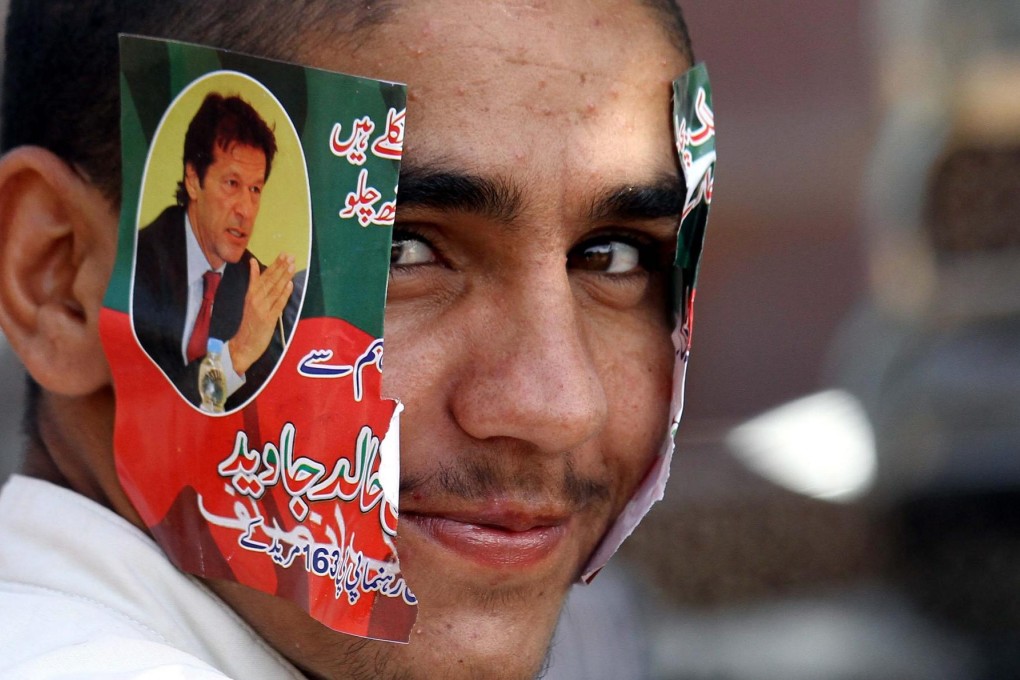 A Khan supporter waits for him to make a speech. Photo: EPA
