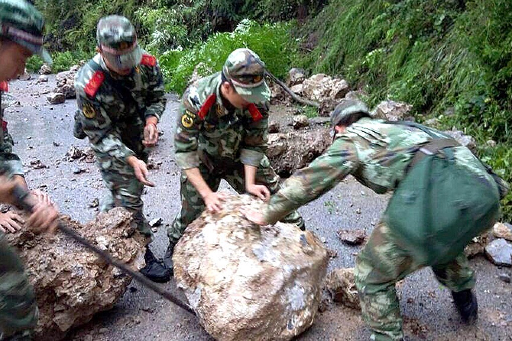 Rescue workers remove debris from a road after a rockfall in Yongshan county. Photo: ImagineChina