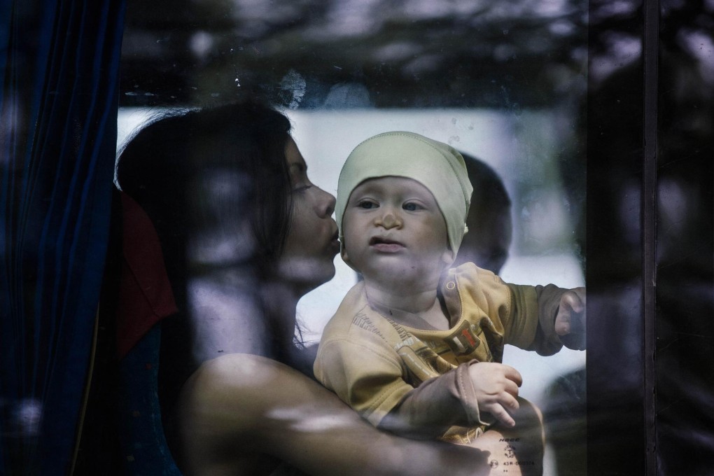 A mother and baby evacuate by bus from the town of Makeyevka in eastern Ukraine yesterday. Photo: AFP