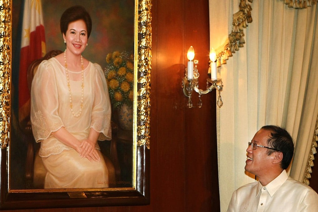 Philippine President Benigno Aquino looks at a portrait of his late mother, former president Corazon Aquino, at the presidential palace in Manila. Photo: AFP