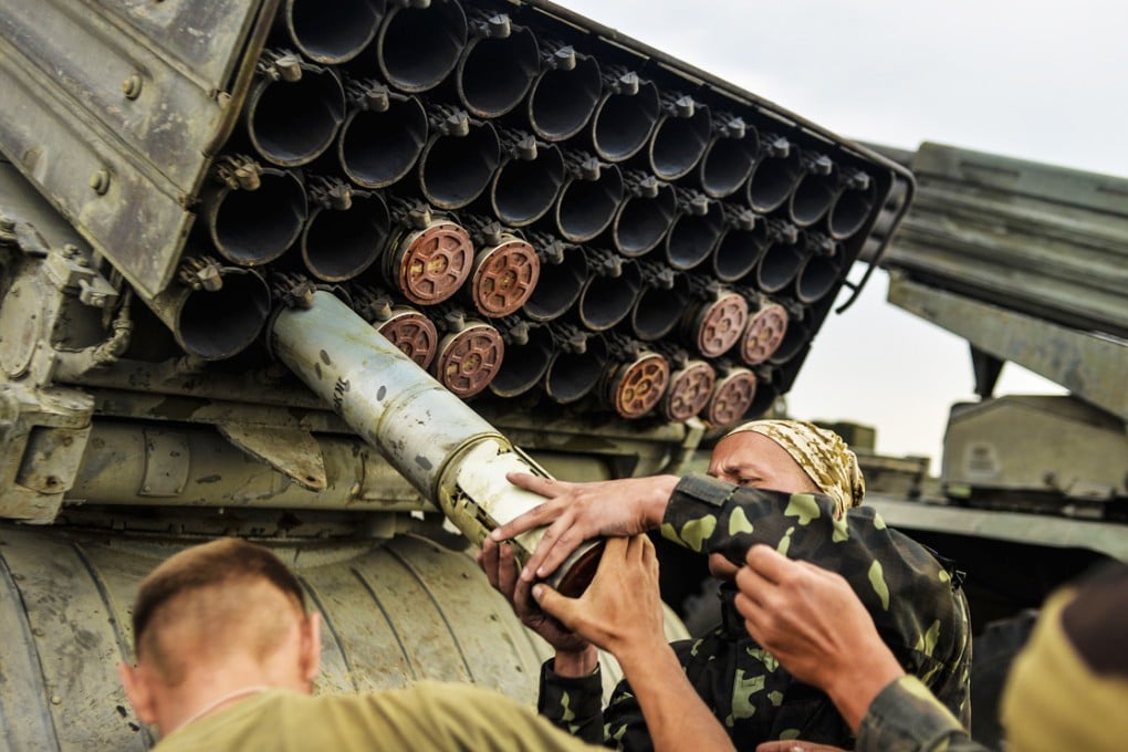 Ukrainian soldiers charge a Grad multiple rocket launcher system, near the eastern Ukrainian city of Shchastya in the Lugansk region. A blame game has ensued between Ukraine's military and rebels over who fired a rocket on the refugee convoy. Photo: AFP