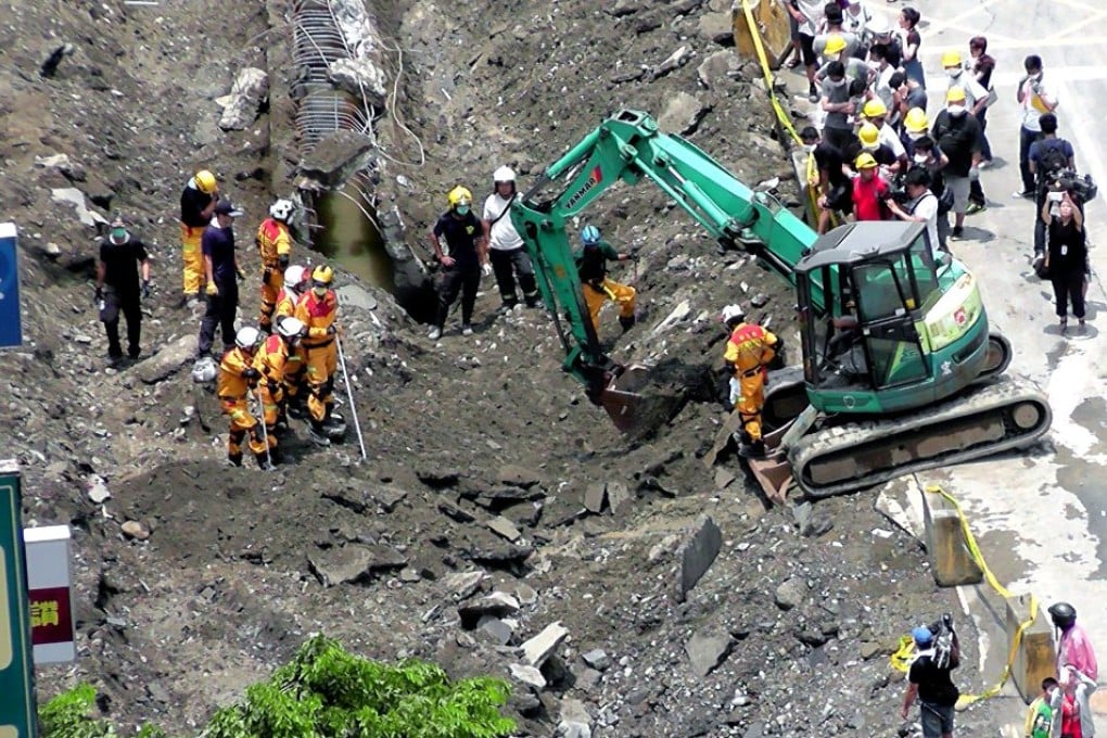 Firemen work at a caved-in road caused by underground gas pipeline explosions in Kaohsiung, Taiwan. Photo: EPA