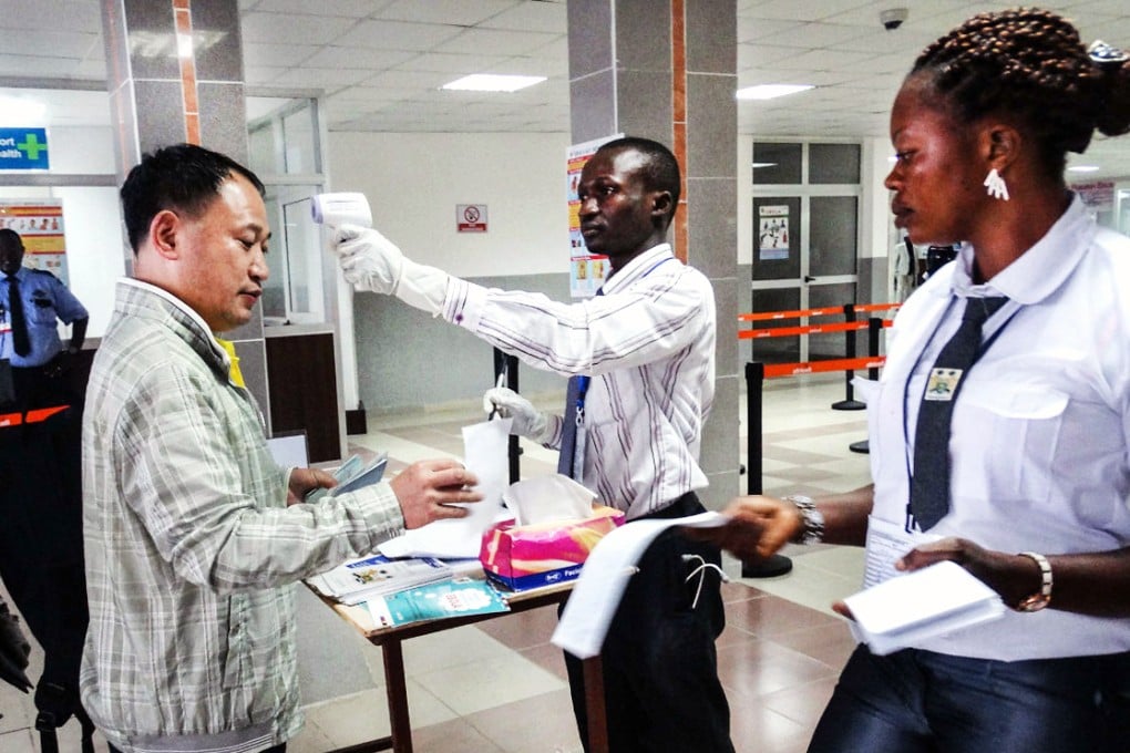 An airport worker measures the body temperature of a Chinese medical expert, at the Lungi International Airport in Freetown, Sierra Leone. Vietnam and Myanmar are the latest countries to test patients for the deadly disease. Photo: Xinhua