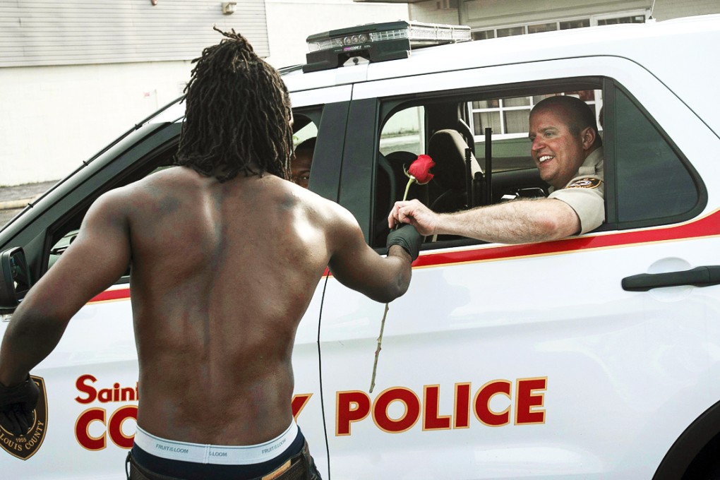 Resident John West hands a rose to a police officer. Photo: Reuters