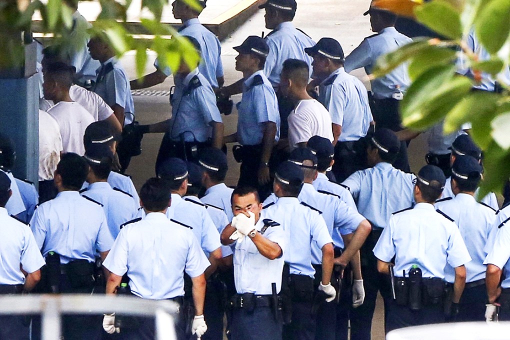 An officer sends photojournalists into a clicking frenzy with his gesture of aiming a gun during the drill. Photo: Nora Tam