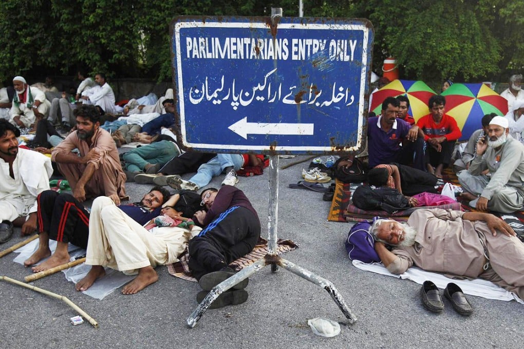 Supporters of cleric Tahir ul-Qadri sleep at the entrance of the parliament house in Islamabad. Protesters have taken to streets of the capital for five days. Photo: Reuters